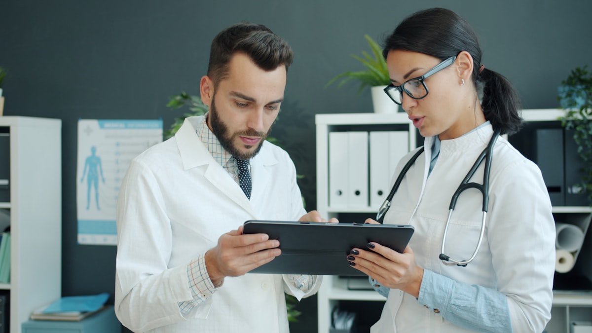 Two doctors reviewing patient data on a tablet